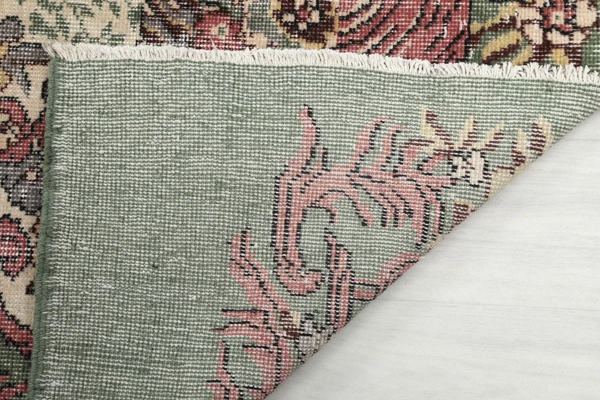Underside of the rug, showing the hand-knotted cotton foundation and fringe