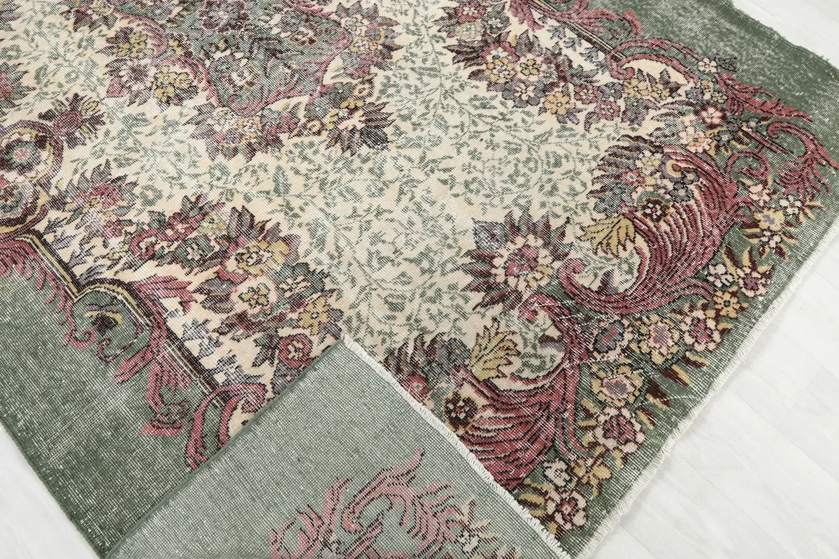 Corner of the rug folded back, revealing the reverse side and knotting detail