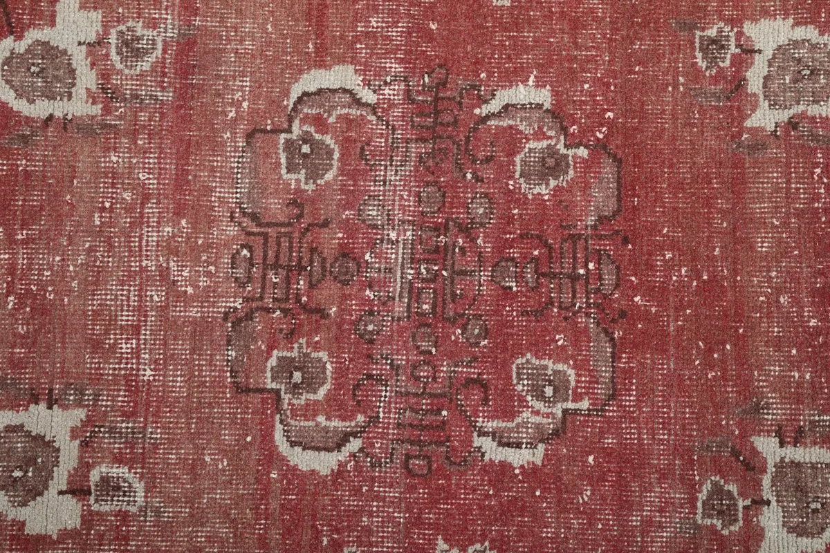 Close-up of the central medallion-like motif and faded rust color