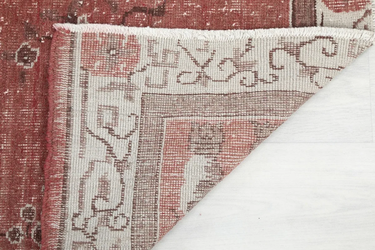 View of the rug's underside, showing the hand-knotted construction and fringe