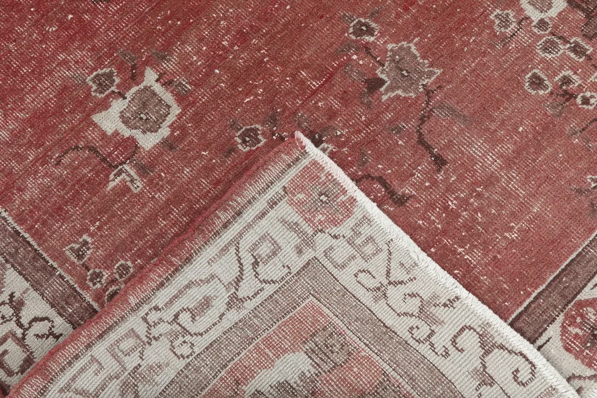 Folded corner of the rug revealing the cotton foundation and knotting