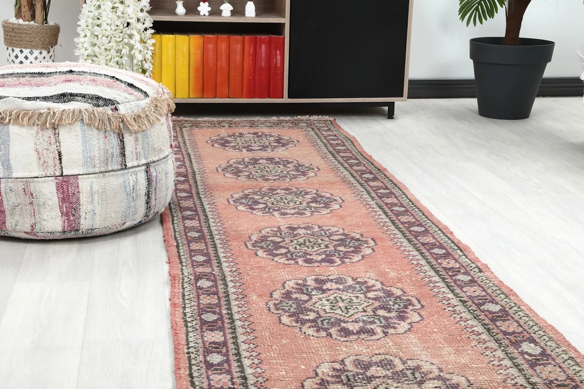 Close-up of the rose runner rug showing medallions and border detail in a room setting