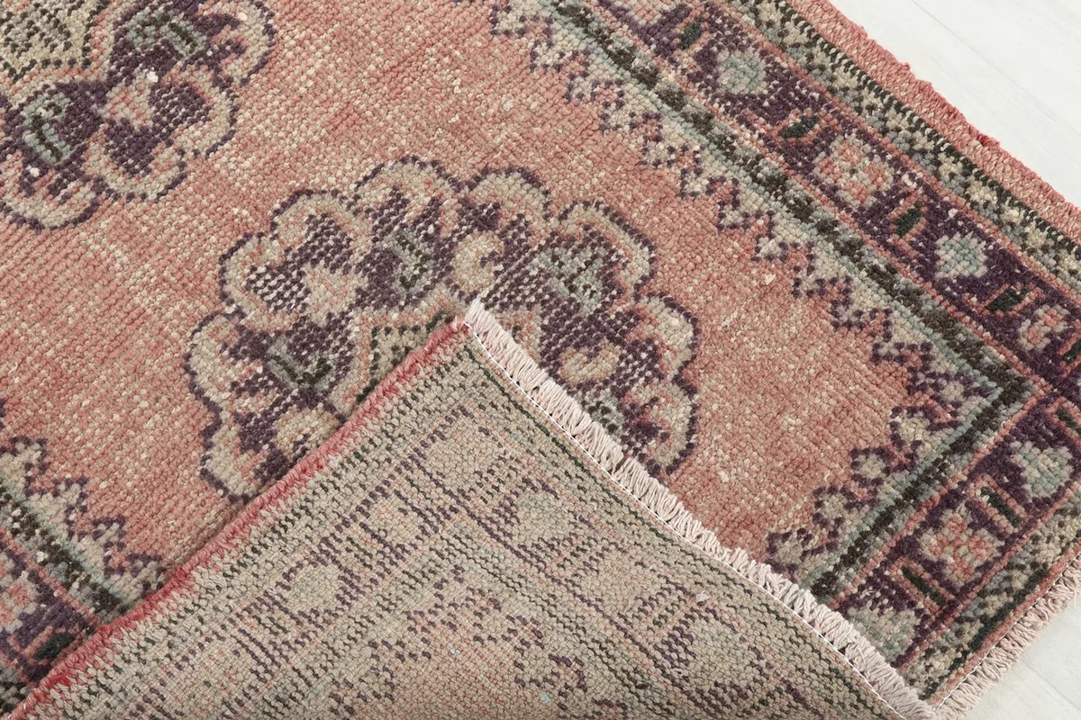 Folded corner of the rug revealing the hand-knotted cotton foundation on the reverse side