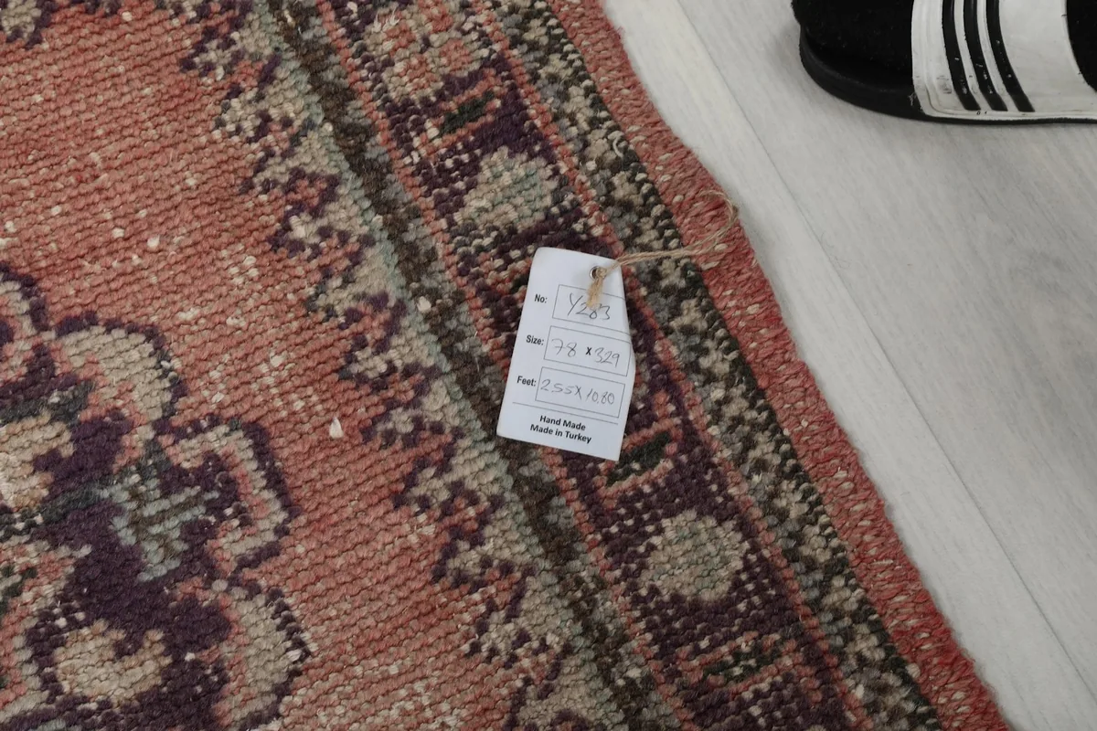 Detail of the rug with a product tag, showing the pile and border texture