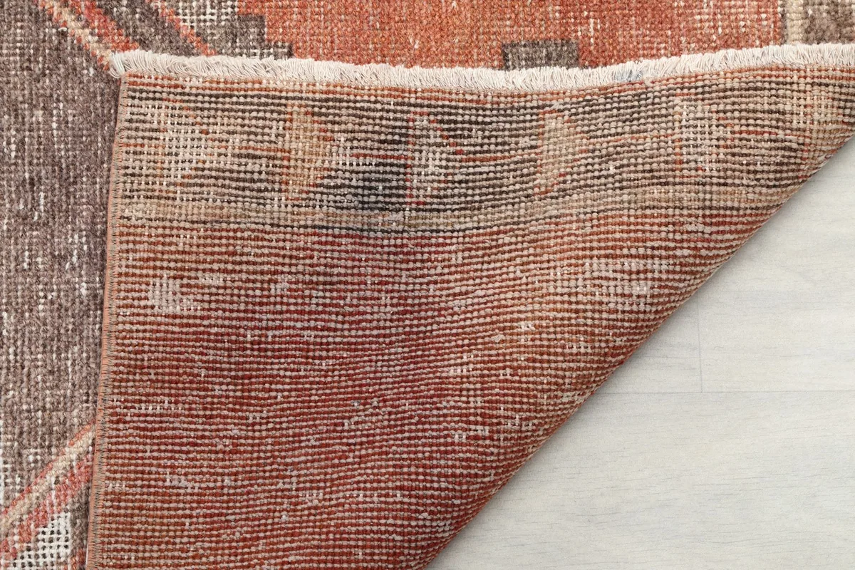 Underside of the rug showing the hand-knotted cotton foundation and the reverse of the wool pile
