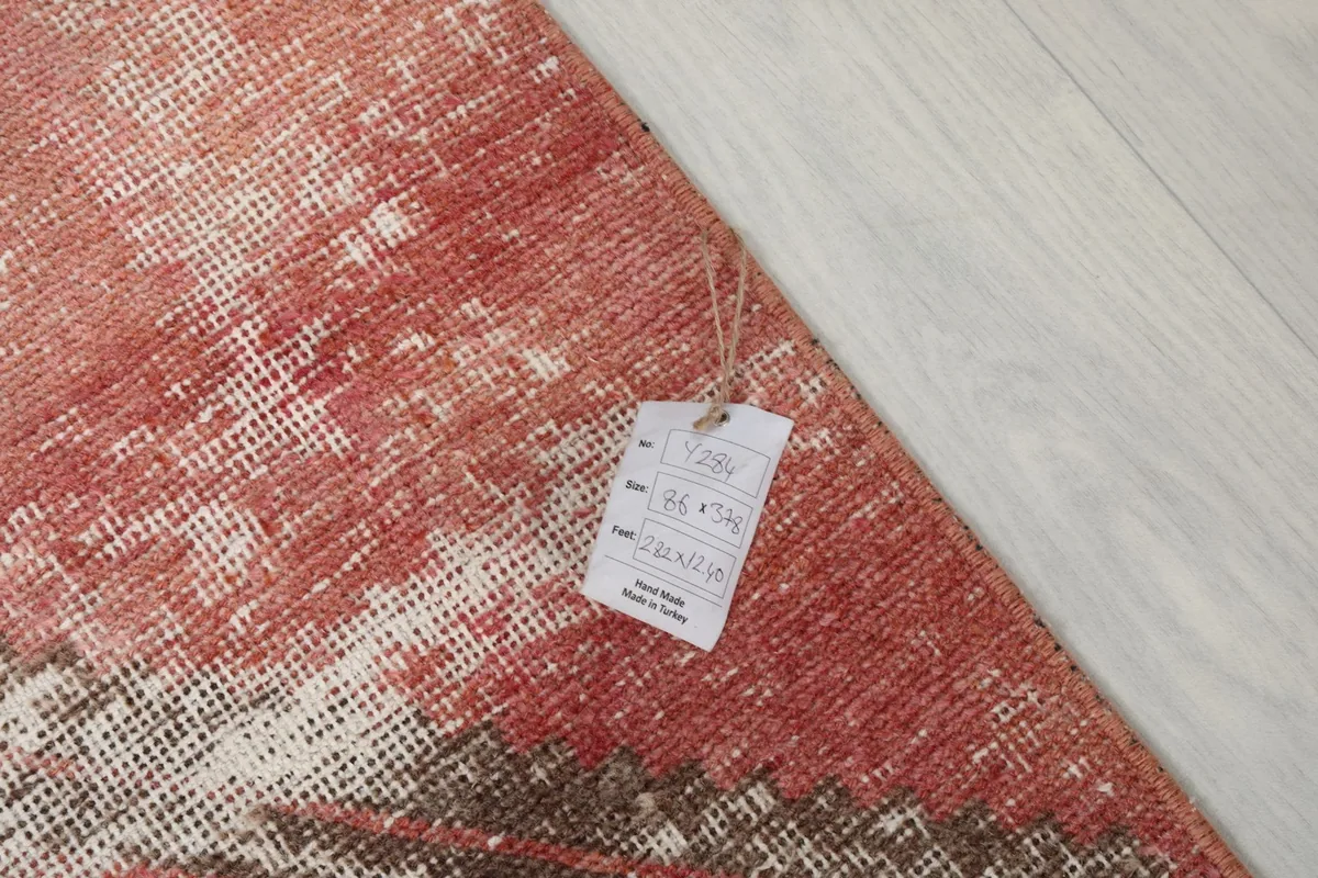 Corner of the rug with a label displaying its dimensions and origin details