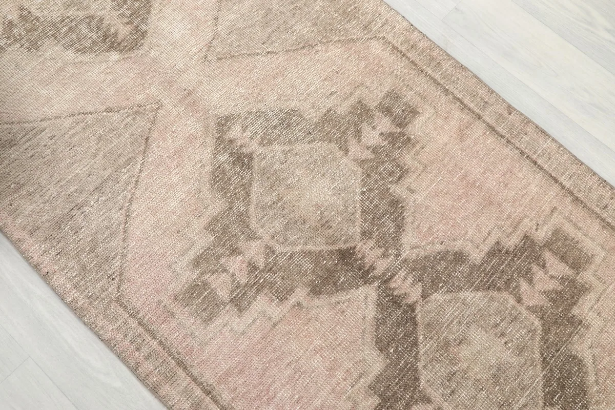 Close-up of a central geometric motif on the runner, revealing the texture and subtle color variations.
