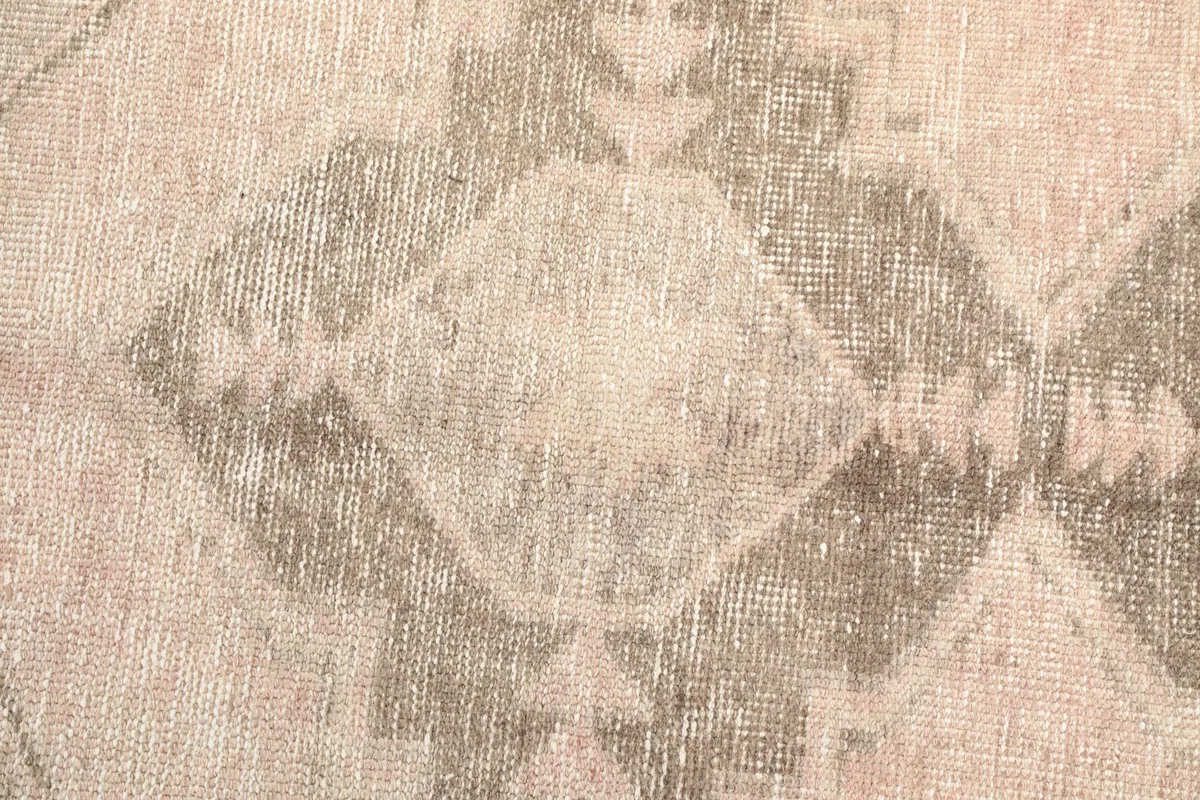 Tight detail of the rug's tribal geometric pattern, highlighting the hand-knotted wool pile.