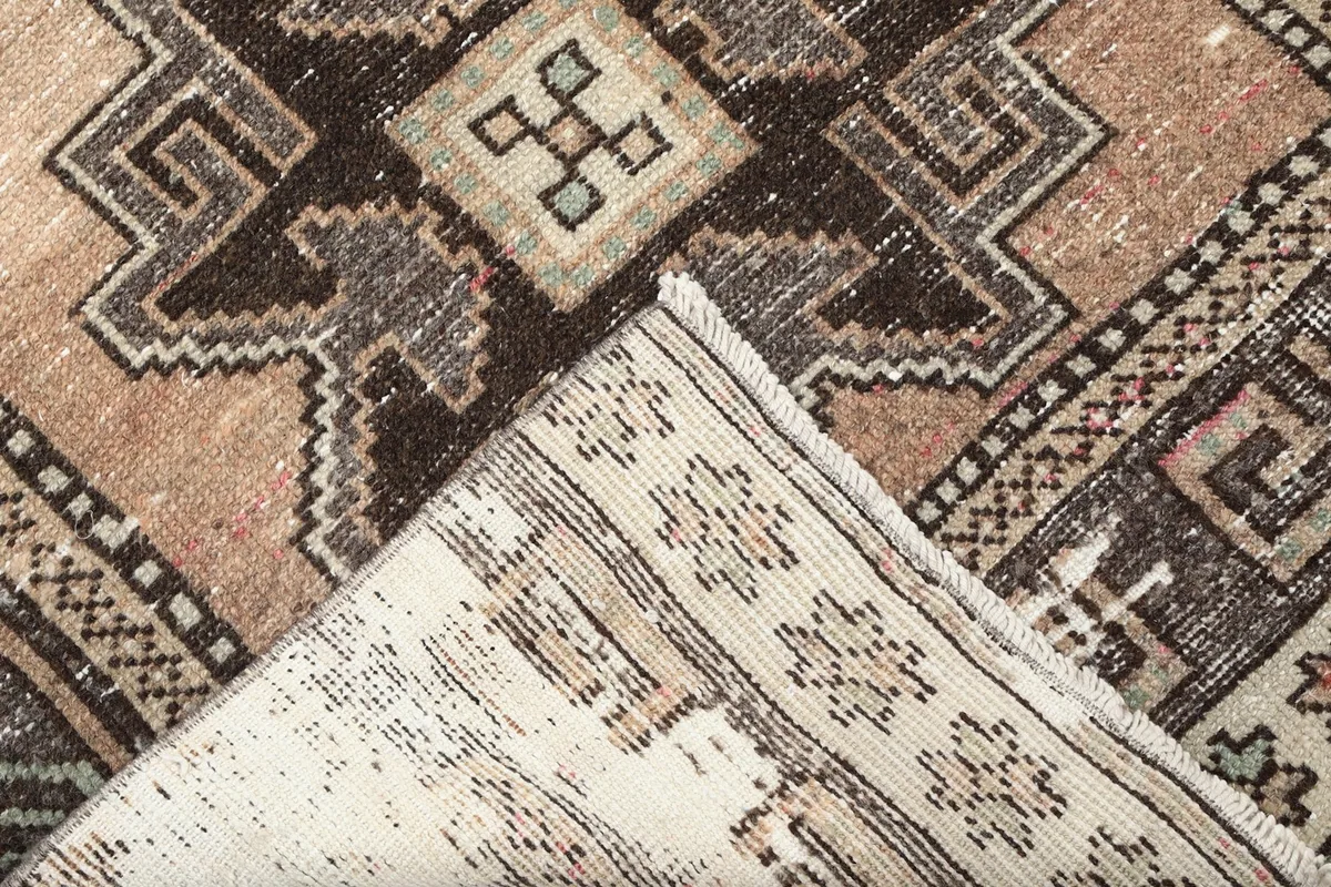 Corner of the rug folded to show the hand-knotted cotton foundation and reverse side