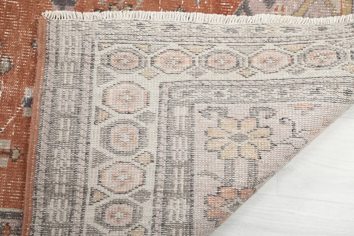 Close-up of the rug's fringe and a corner with the border design.