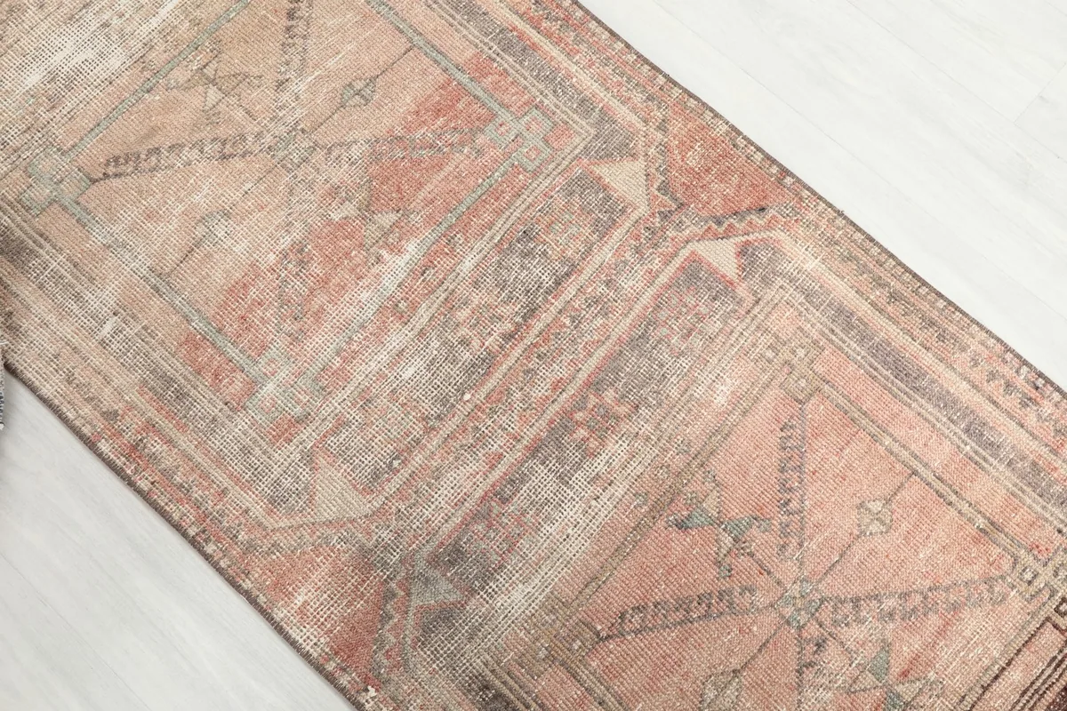 Overhead shot focusing on a section of the runner, displaying its repeated geometric design and patina.