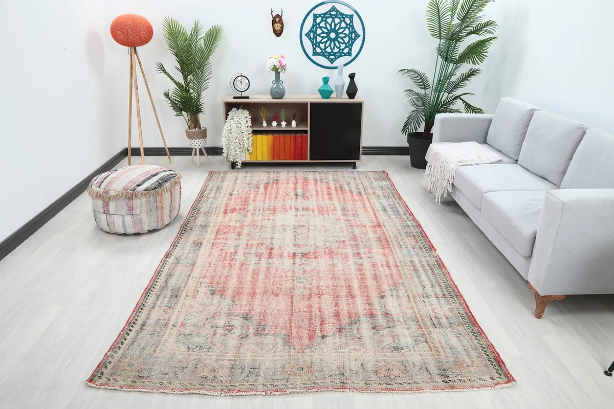 Vintage area rug displayed in a living room setting with a sofa and decor