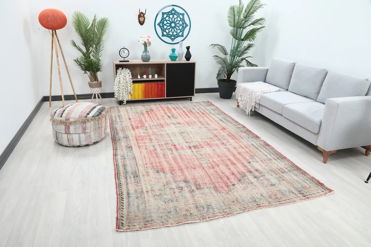 Angle view of the rose and charcoal rug in a living room, showing its size in context