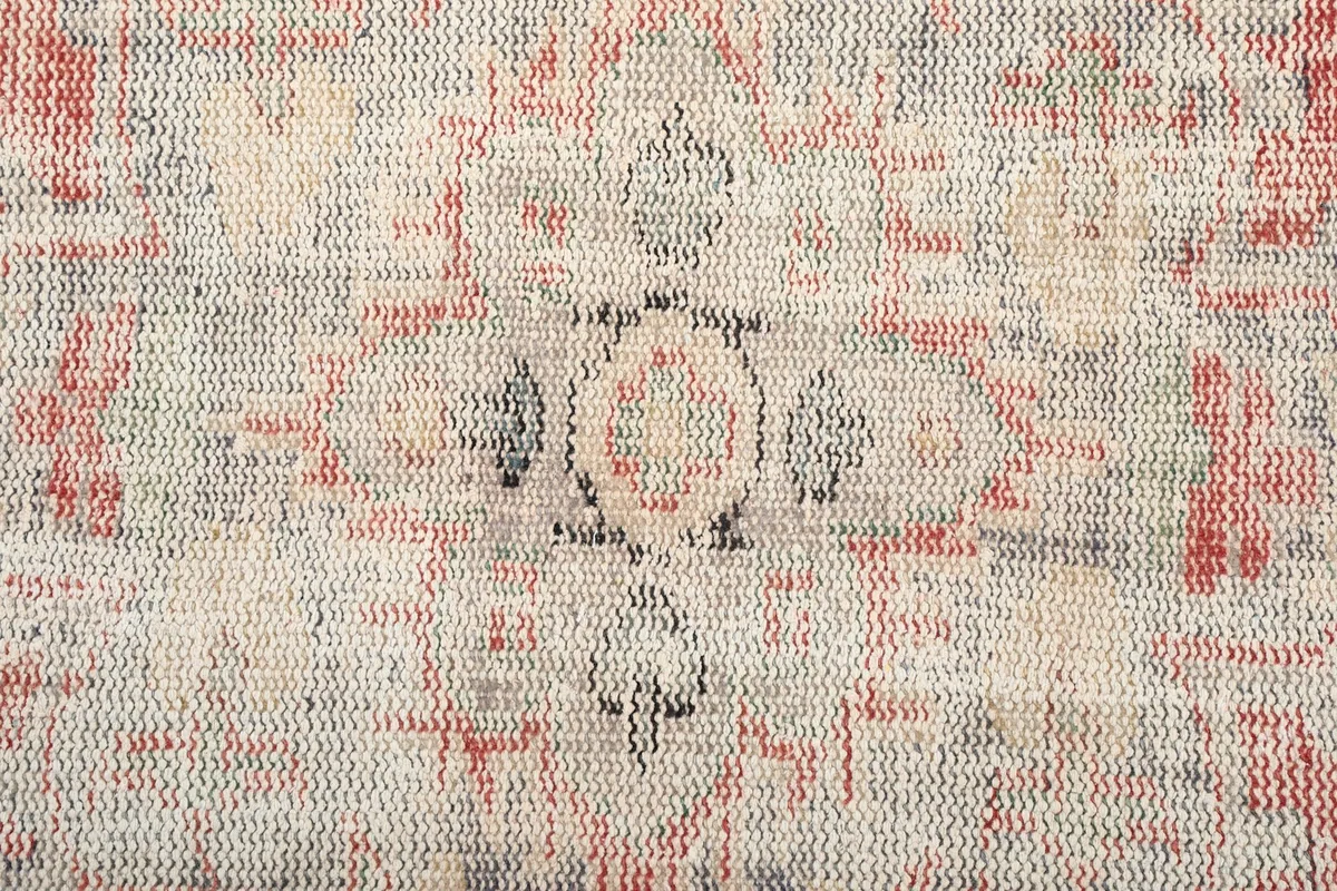 Close-up detail of the faded central motif and intricate geometric weaving