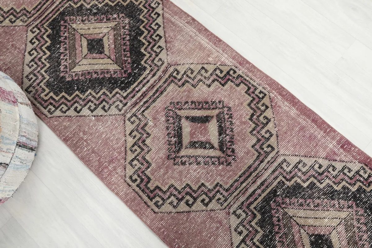 Overhead angle shot of the runner rug, focusing on the repeating diamond motifs and the rose field.