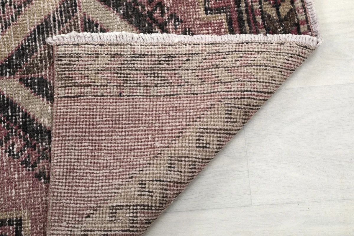 View of the back of the hand-knotted rug, showcasing the cotton foundation and tight weave.