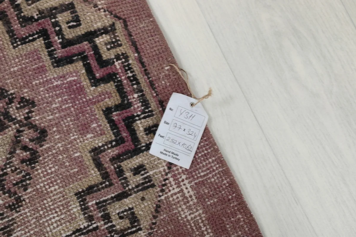 Close-up of the rug with a product tag, indicating its size and vintage origin.