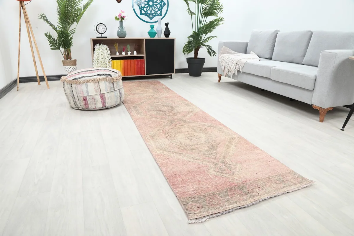 Angle view of the rose geometric runner rug in a room with light flooring and gray sofa