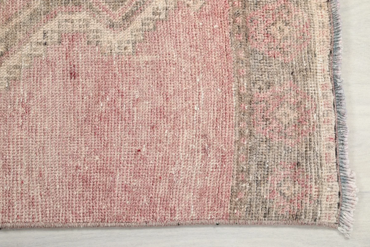 Close-up showing the low wool pile and texture of the rose vintage runner