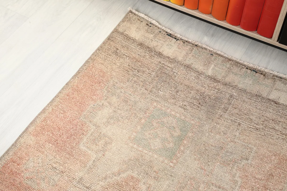 Angled view of one end of the runner, showing the soft rose hues and subtle pattern details.