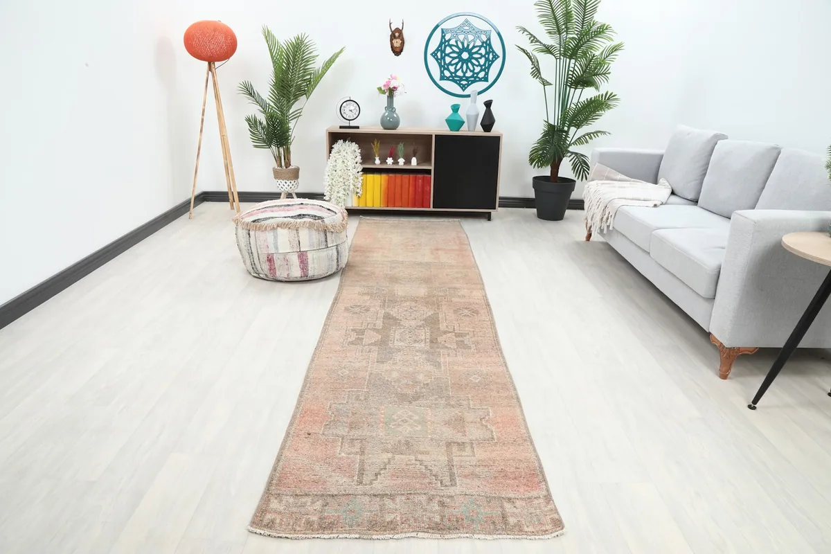Vintage Anatolian runner rug laid out in a modern hallway with light flooring and furniture.