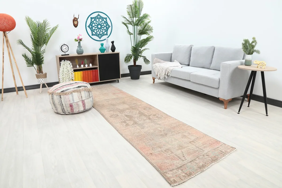 Angle view of the rose and gray runner rug extending through a hallway, showcasing its length.