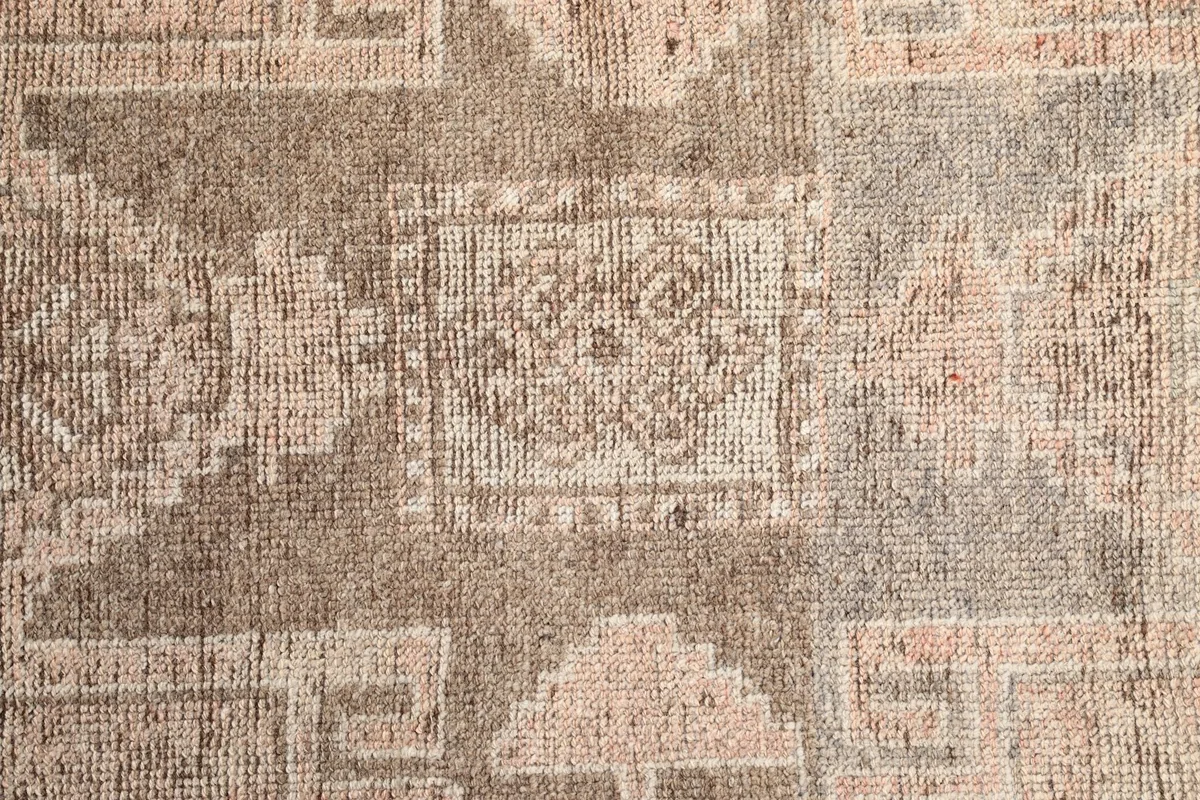 Extreme close-up of the rug's surface, revealing the intricate geometric patterns and textural details.