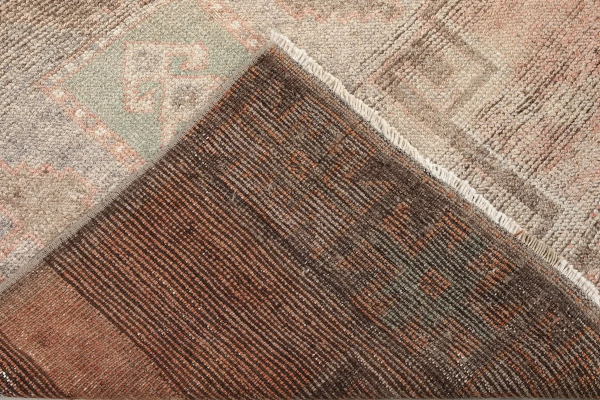 Corner view of the rug's back, showing the consistent knotting and quality of the vintage textile.