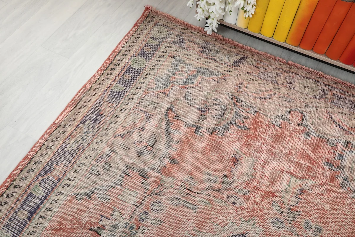 Overhead angle of the vintage rug, capturing its distressed appearance and colors