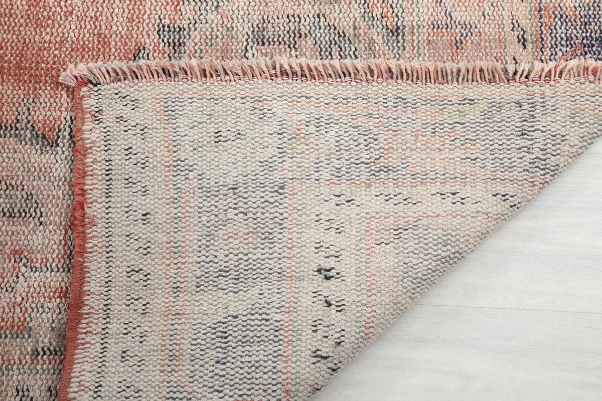 Underside of the hand-knotted rug, showing the cotton foundation and knotting