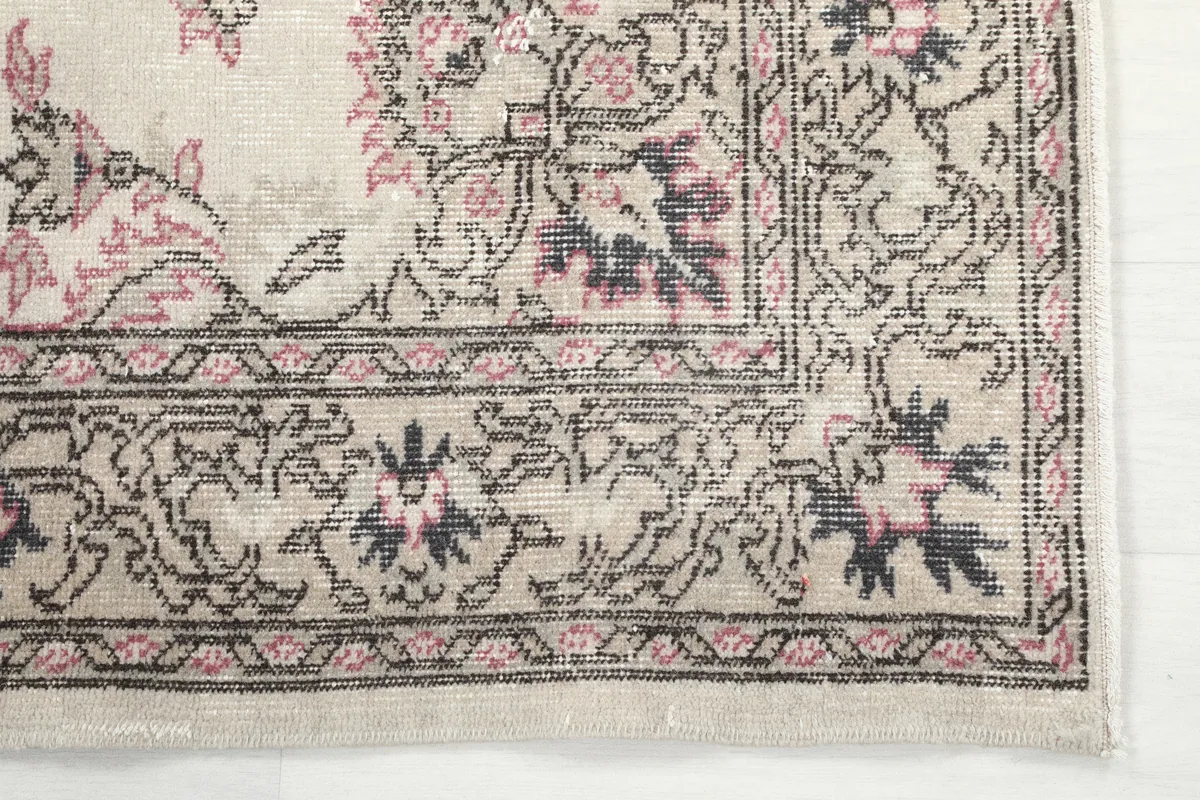Detail of the border design with rose and gray patterns on the Ivory Rose Medallion Anatolian Rug.