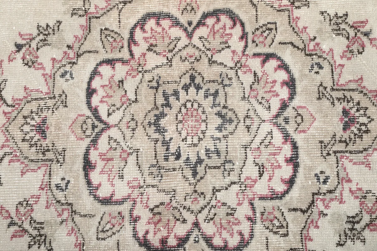 Extreme close-up of the central medallion, showing the hand-knotted wool pile and color variations.