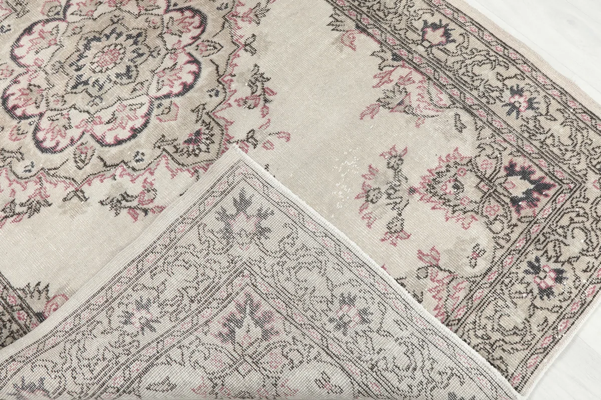 Corner of the Ivory Rose Medallion Anatolian Rug flipped to show the cotton foundation and reverse side of the knotting.