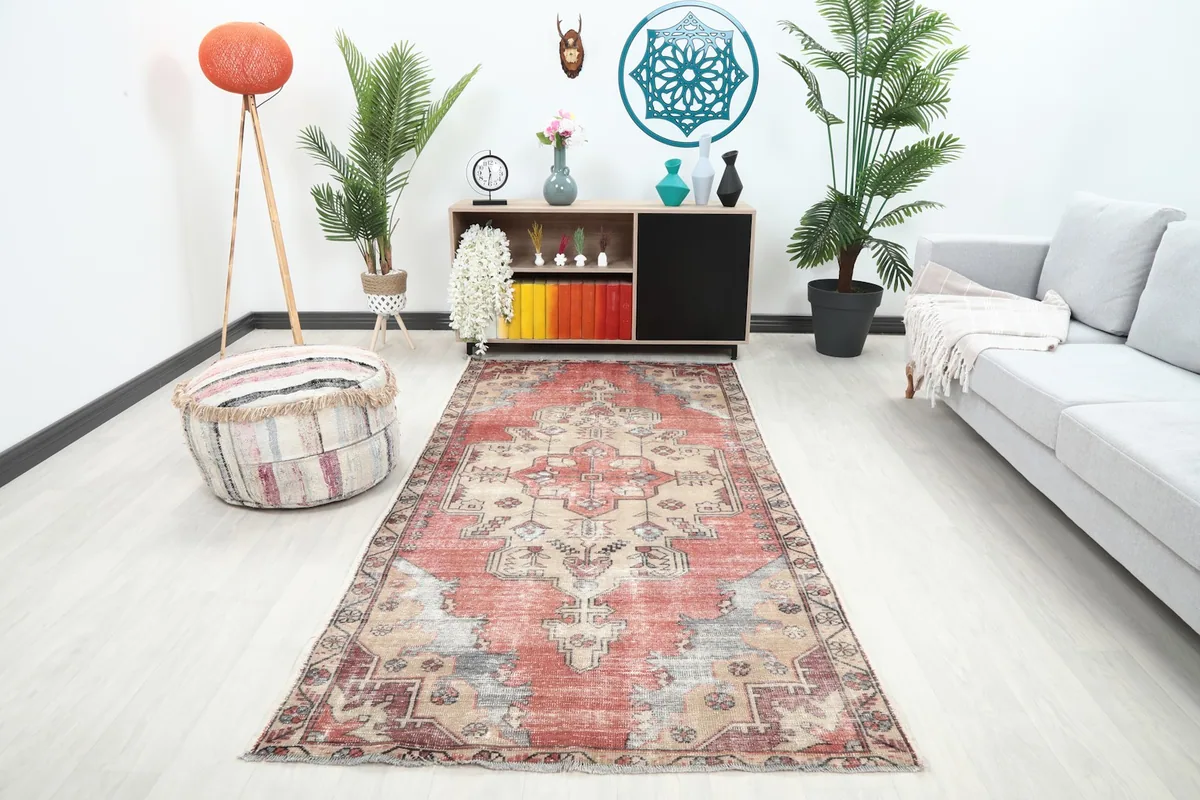 Vintage red and beige rug in a modern living room setting with a gray sofa