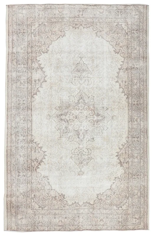Full overhead view of the vintage Anatolian ivory and brown medallion area rug on a white background.