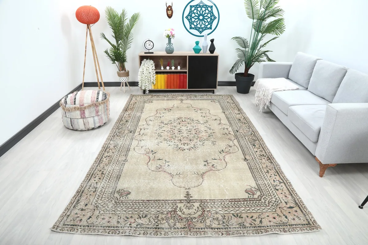Large beige floral medallion rug displayed in a bright living room setting