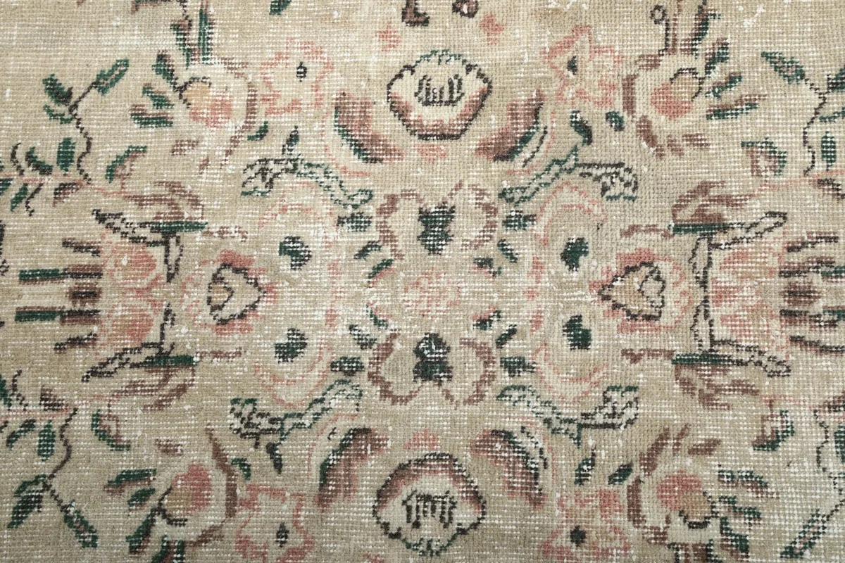 Detailed shot of the wool pile showing the faded rose and green colors in the medallion