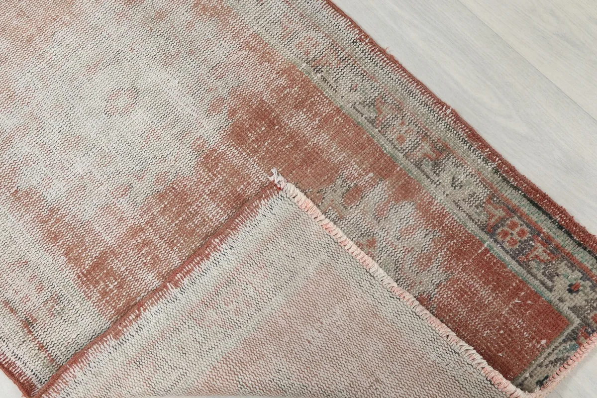 Folded corner of the runner rug, revealing the wool pile and cotton foundation