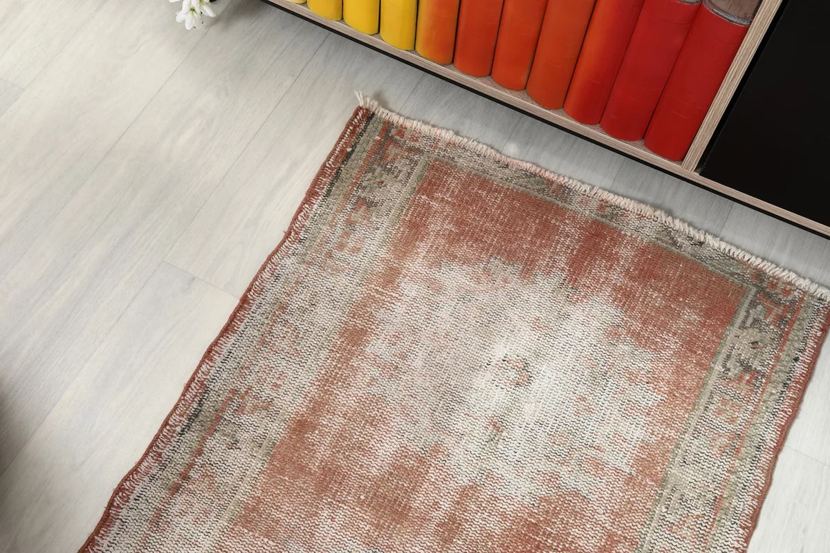 Top-down view of one end of the runner rug, showing its placement near a bookshelf