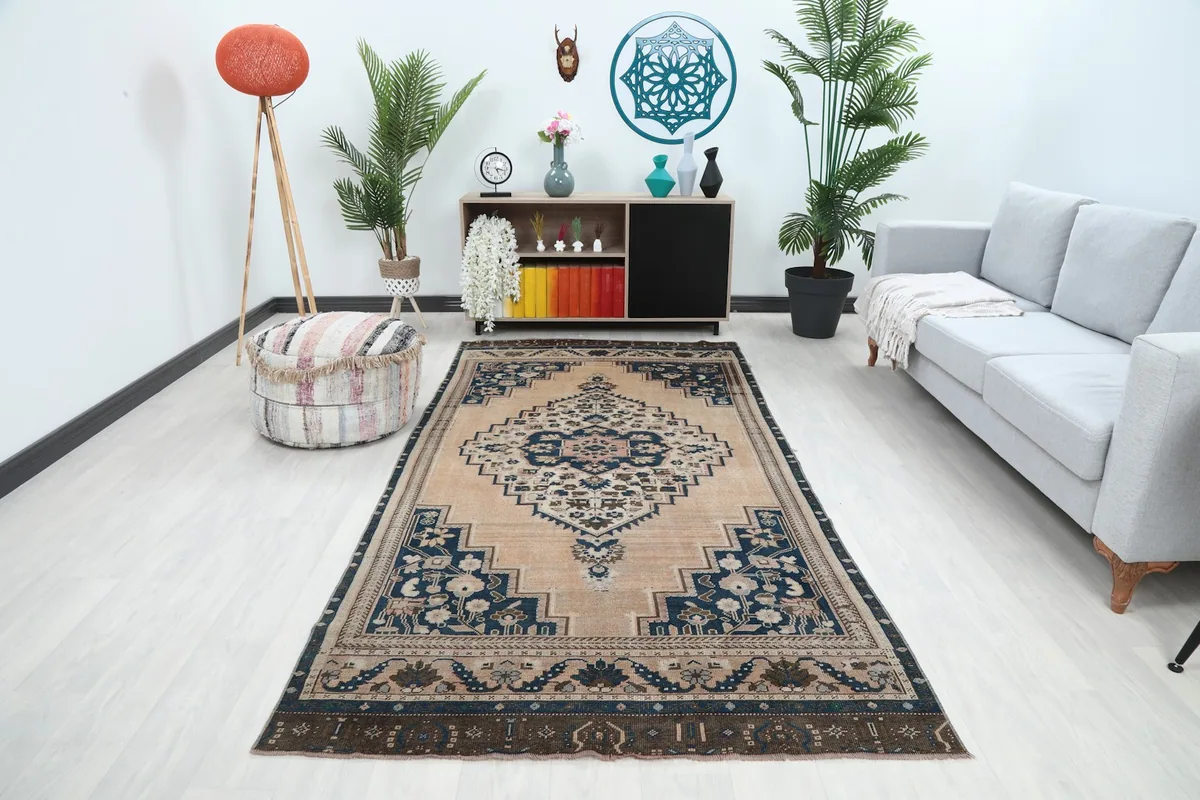 Vintage Anatolian rug displayed in a living room setting with a light couch and plants