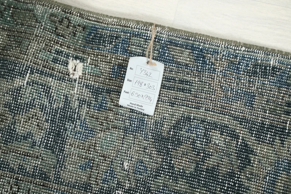 Reverse side of the rug showing the hand-knotted construction and product tag