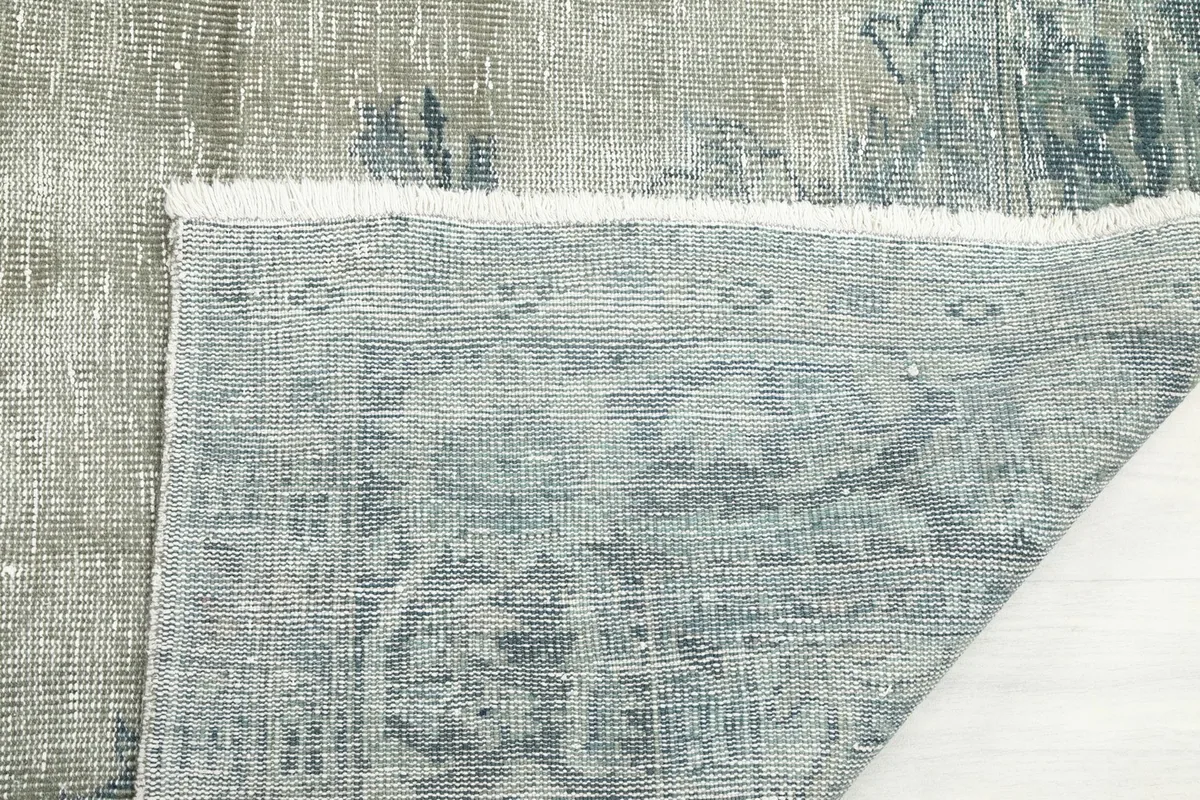Close-up of the rug's fringe and the hand-knotted structure from the underside