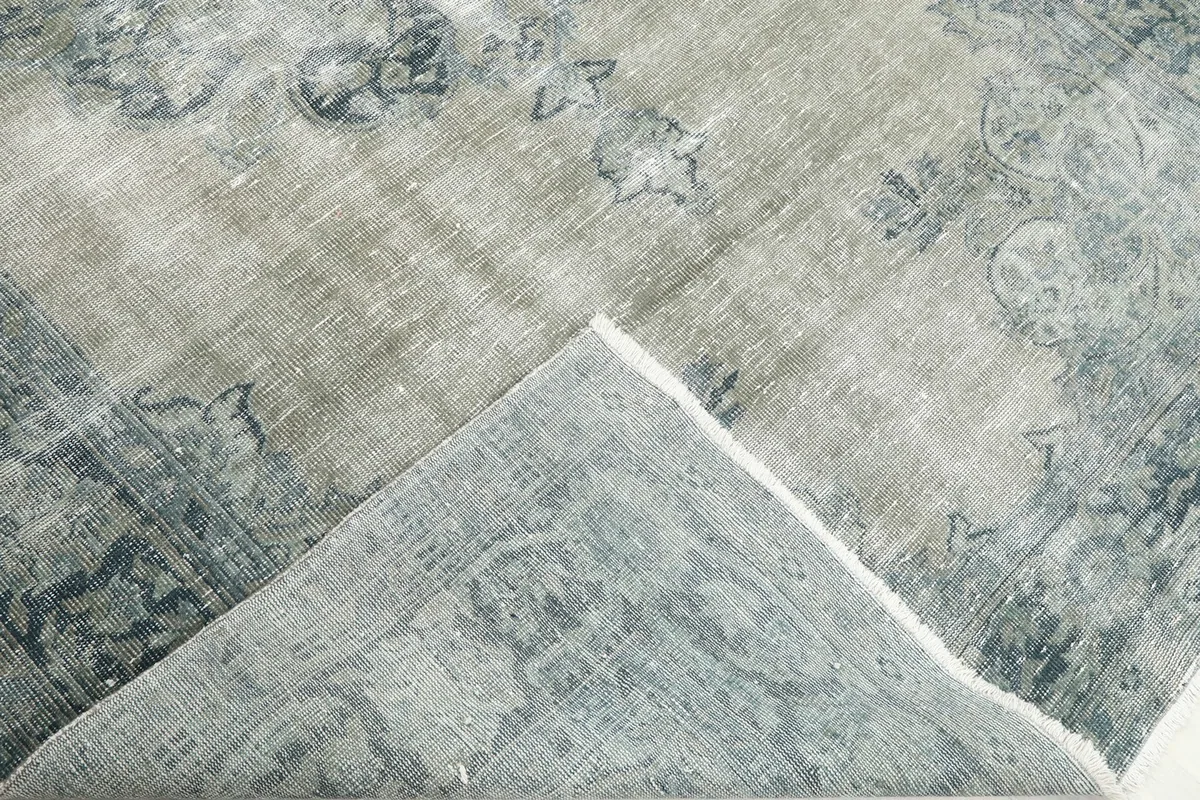 Folded corner of the rug revealing the cotton foundation and reverse side
