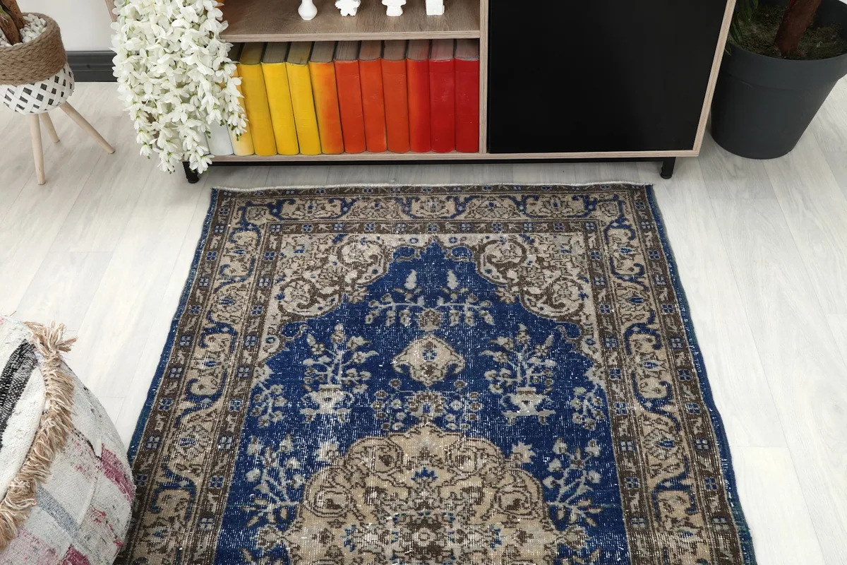 Overhead angle of the blue rug, emphasizing its shape and the decorative elements around the medallion