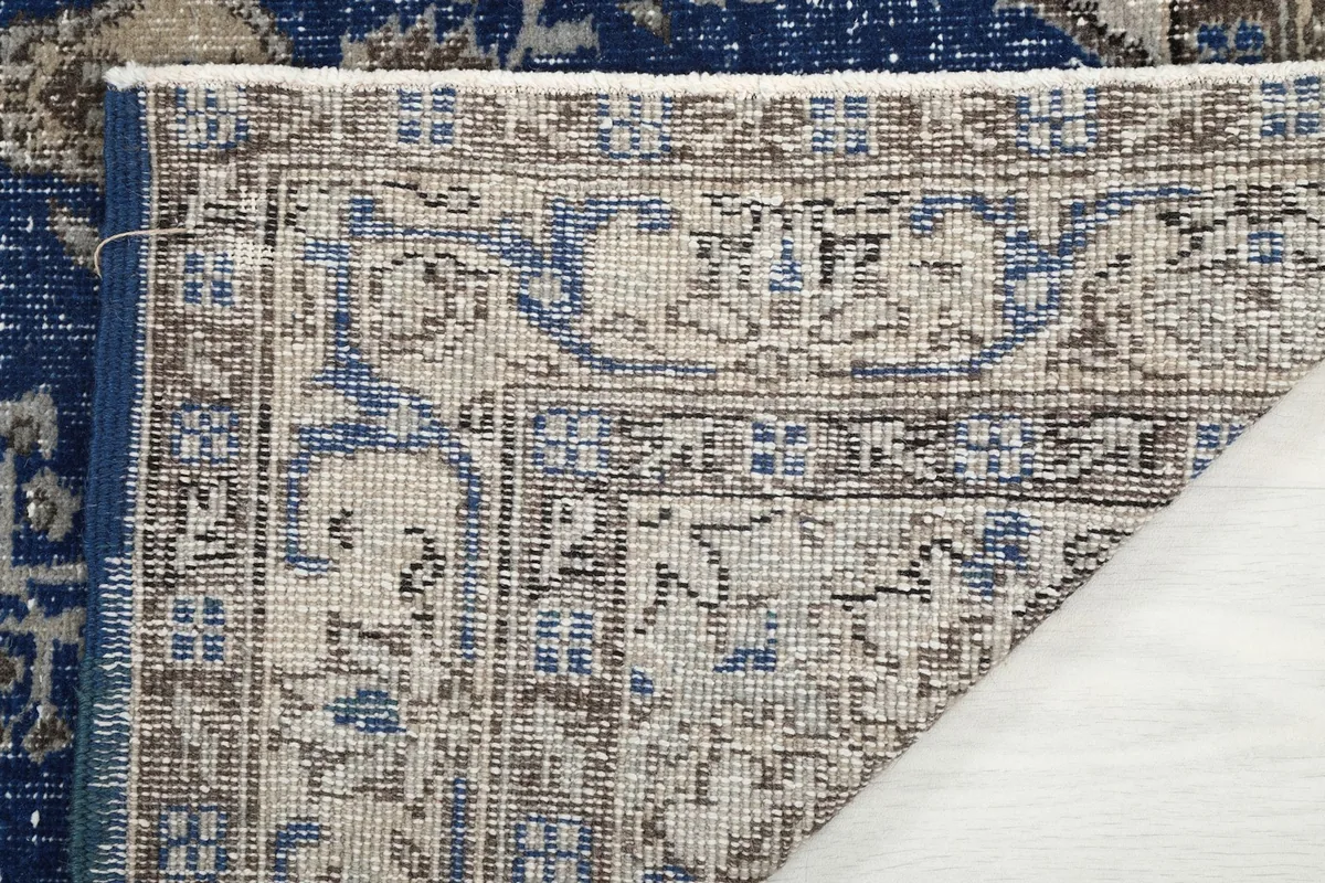 Underside of the rug showing the cotton foundation and reverse of the hand-knotted wool pile