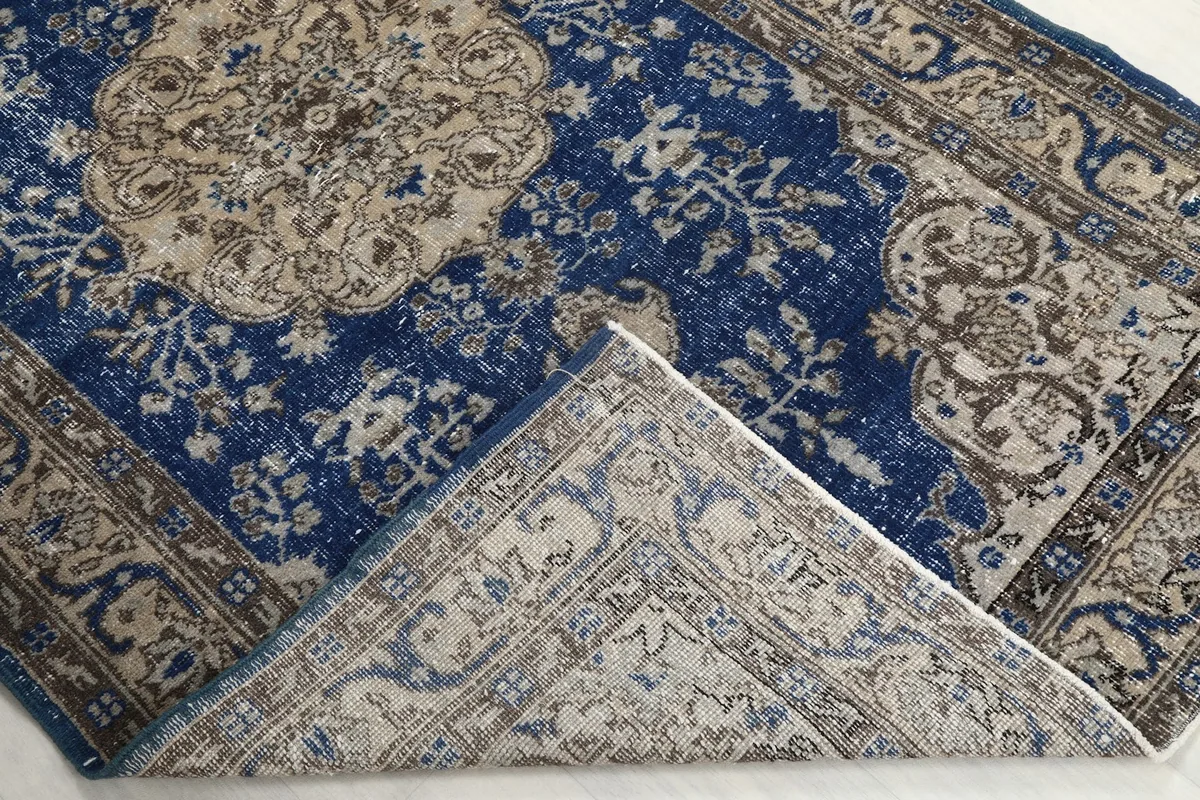 Folded corner of the rug, revealing the backing and the thickness of the wool pile