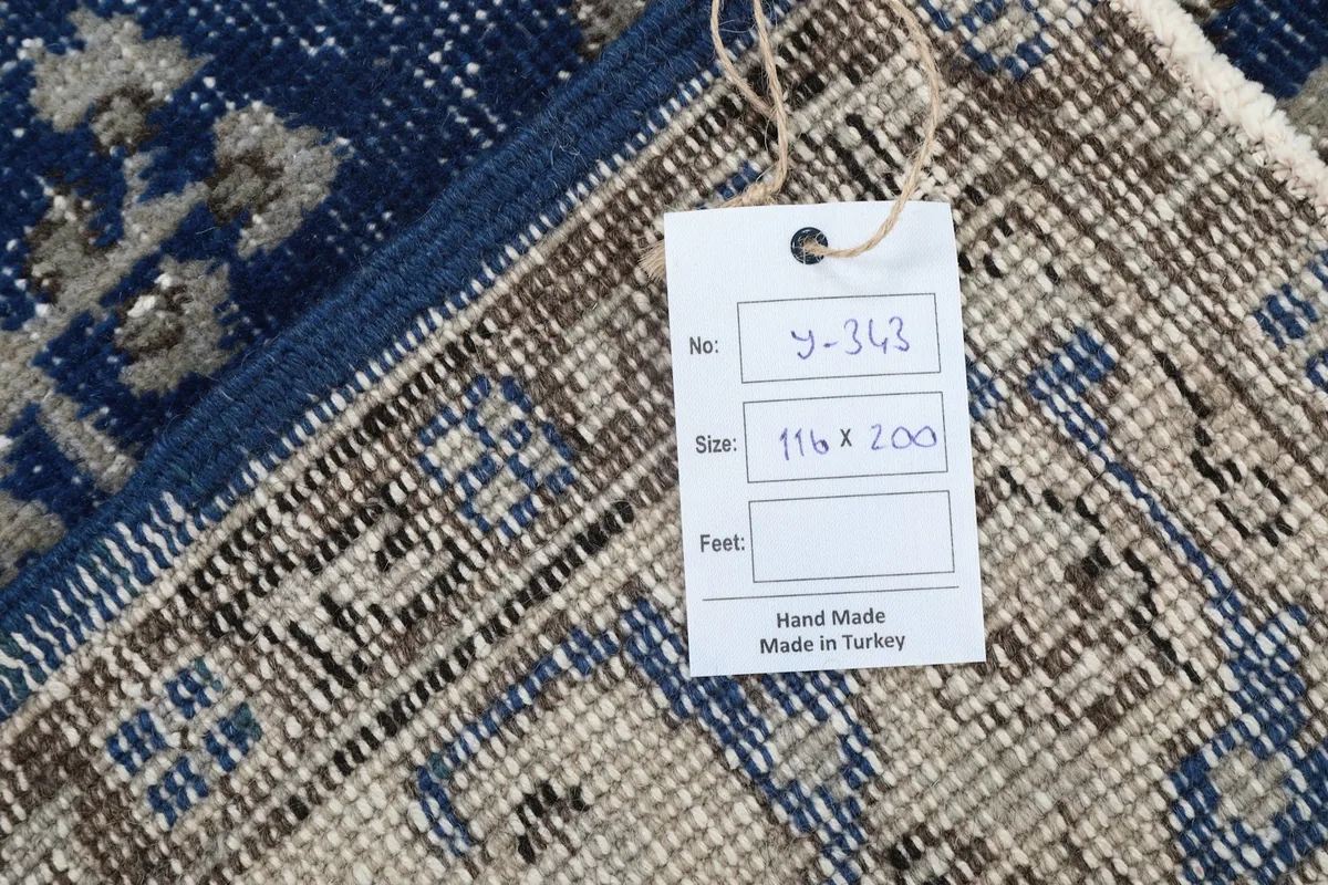 Close-up of the rug tag, showing size and origin details, 'Hand Made in Turkey'