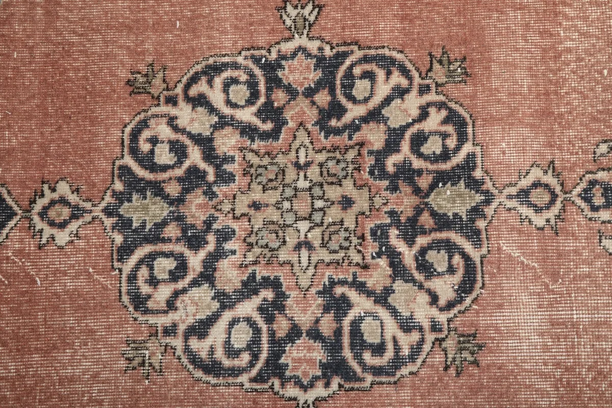 Extreme close-up of the intricate patterns within the central medallion of the rug.