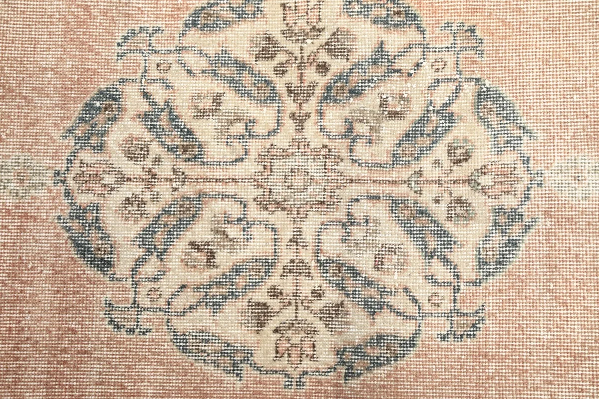 Detailed view of the intricate blue and beige floral and geometric patterns within the central medallion.