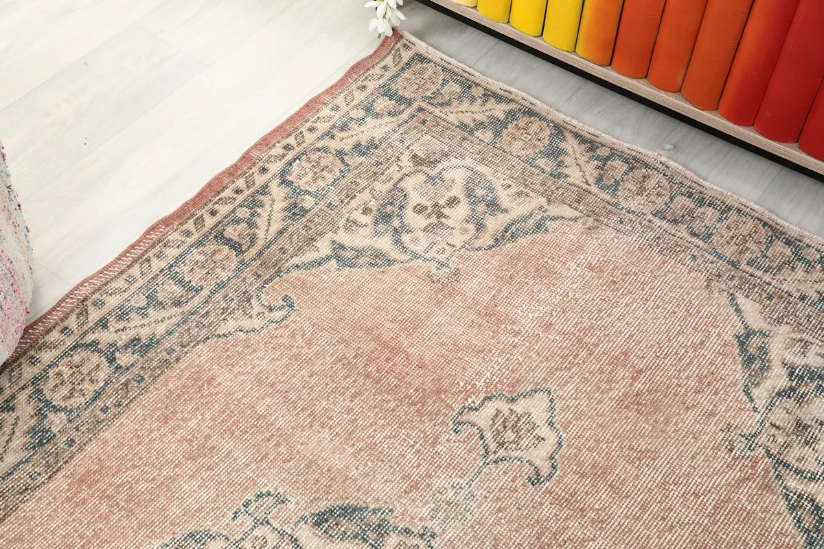 Close-up of the upper left corner of the rug, highlighting the detailed blue and beige border design.